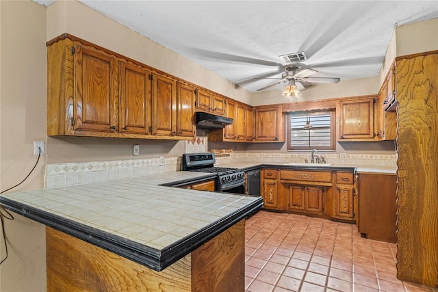 720 W 3rd St, Watonga, OK 73772 - kitchen with stainless steel gas stove, under cabinet range hood, a sink, tile counters, and brown cabinets