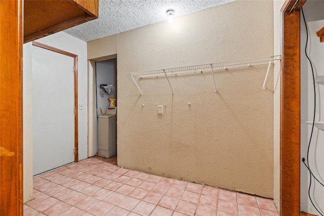 720 W 3rd St, Watonga, OK 73772 - laundry room with a textured wall, washer / dryer, light tile patterned floors, and a textured ceiling