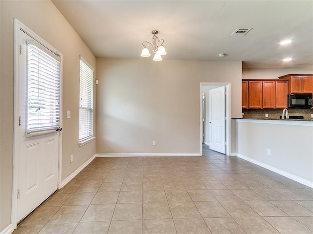 9708 Squire Ln, Yukon, OK 73099 - kitchen featuring black microwave, backsplash, light tile patterned flooring, dark countertops, and a chandelier