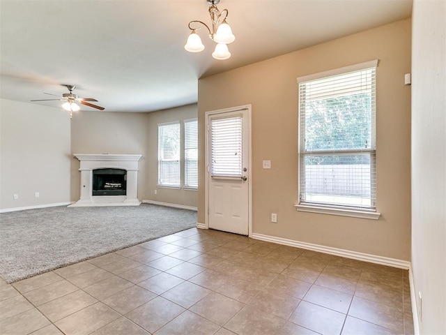 9708 Squire Ln, Yukon, OK 73099 - unfurnished living room with light colored carpet, light tile patterned floors, a chandelier, a ceiling fan, and a fireplace with raised hearth