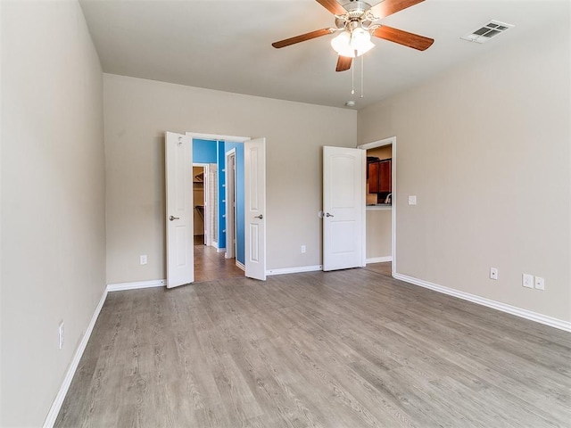 9708 Squire Ln, Yukon, OK 73099 - unfurnished bedroom with a spacious closet, wood finished floors, ceiling fan, and a closet