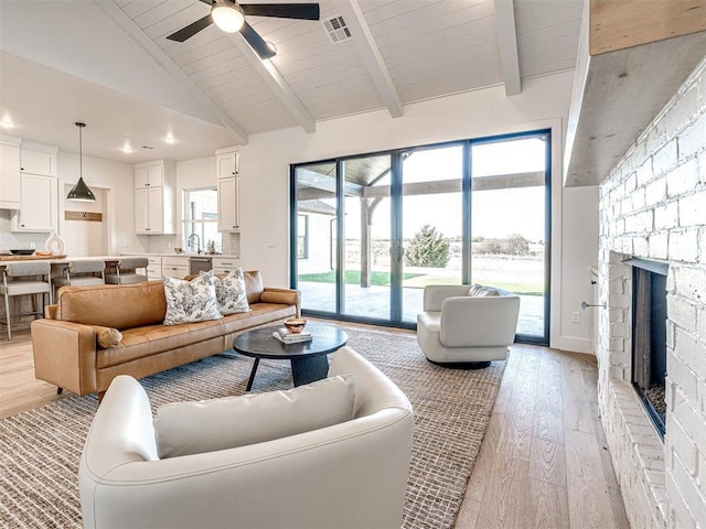 13133 Ashlyn Ln, Yukon, OK 73099 - living area with light wood finished floors, a fireplace, ceiling fan, plenty of natural light, and high vaulted ceiling