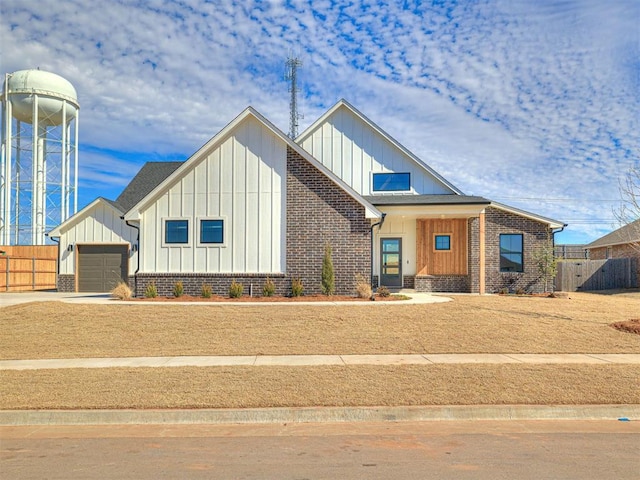 9608 Sultans Water Way, Yukon, OK 73099 - modern farmhouse with board and batten siding, an attached garage, brick siding, and driveway
