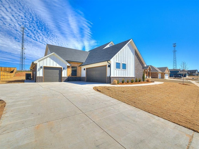 9608 Sultans Water Way, Yukon, OK 73099 - view of front of home with board and batten siding, an attached garage, concrete driveway, roof with shingles, and brick siding