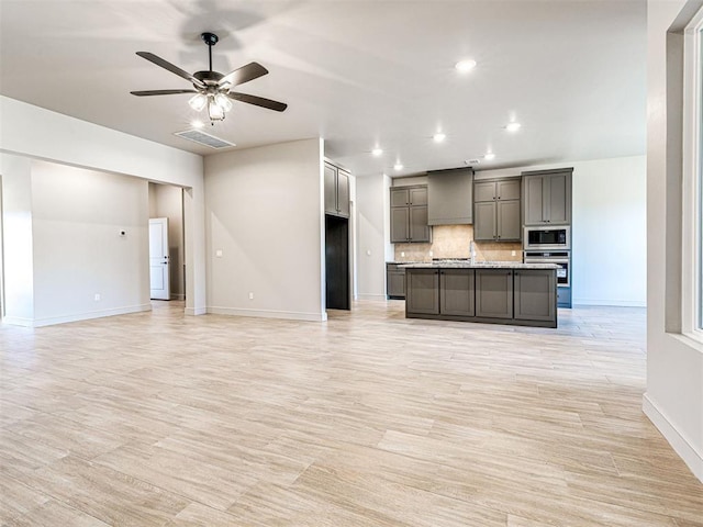 9608 Sultans Water Way, Yukon, OK 73099 - kitchen with stainless steel appliances, baseboards, tasteful backsplash, a ceiling fan, and light wood-type flooring