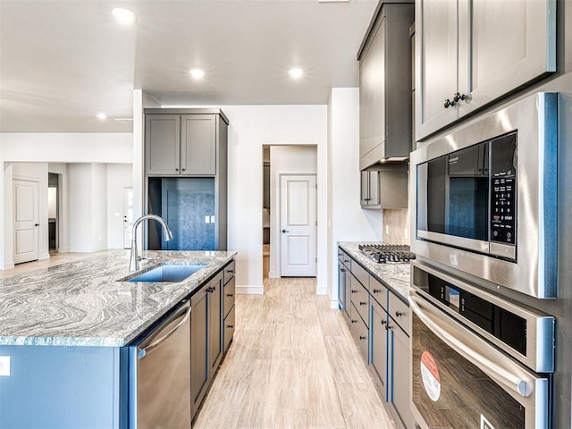 9608 Sultans Water Way, Yukon, OK 73099 - kitchen with stainless steel appliances, a sink, light stone countertops, baseboards, and gray cabinetry