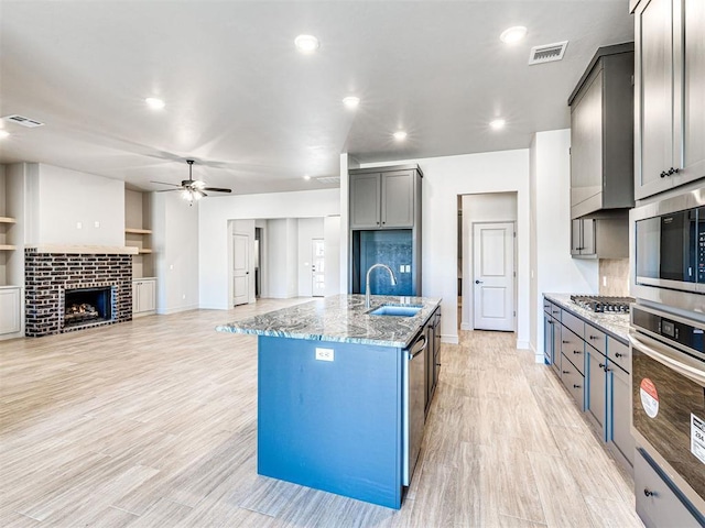 9608 Sultans Water Way, Yukon, OK 73099 - kitchen featuring a sink, stainless steel appliances, ceiling fan, light stone counters, and baseboards