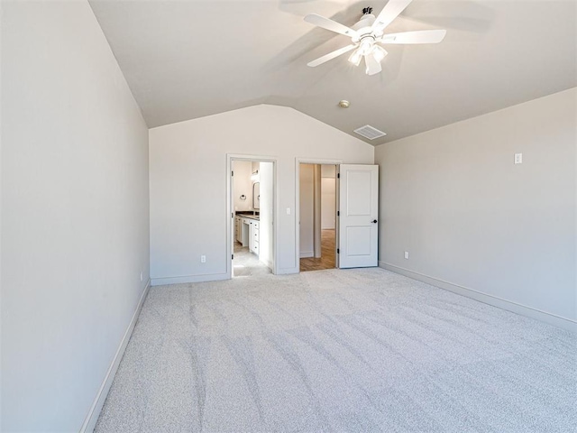 9608 Sultans Water Way, Yukon, OK 73099 - unfurnished bedroom featuring vaulted ceiling, baseboards, light carpet, ensuite bath, and a ceiling fan