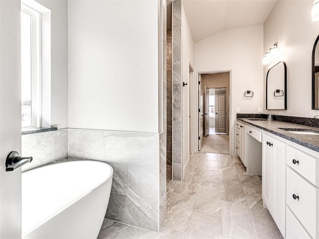 9608 Sultans Water Way, Yukon, OK 73099 - bathroom featuring double vanity, a freestanding tub, lofted ceiling, marble finish flooring, and tiled shower