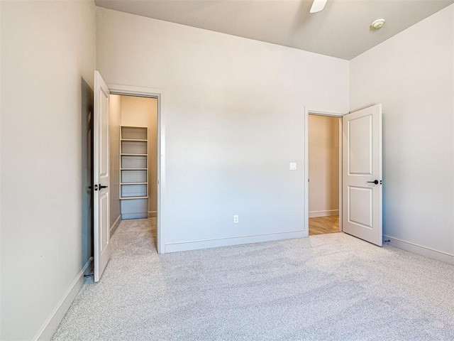 9608 Sultans Water Way, Yukon, OK 73099 - unfurnished bedroom with carpet, a walk in closet, baseboards, and ceiling fan