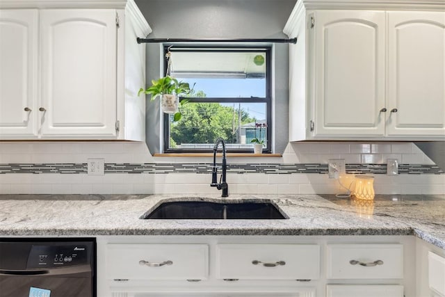 7921 NW 40th St, Bethany, OK 73008 - kitchen featuring dishwasher, a sink, backsplash, and white cabinetry