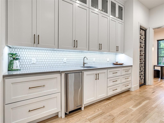 15825 Lacebark Ln, Edmond, OK 73013 - kitchen with a sink, light wood-style flooring, backsplash, fridge, and white cabinetry