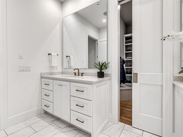 15825 Lacebark Ln, Edmond, OK 73013 - bathroom featuring marble look tiles, vanity, baseboards, and recessed lighting