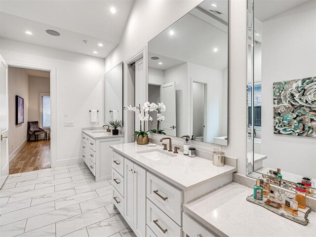 15825 Lacebark Ln, Edmond, OK 73013 - bathroom with two vanities, recessed lighting, lofted ceiling, and marble look tiles
