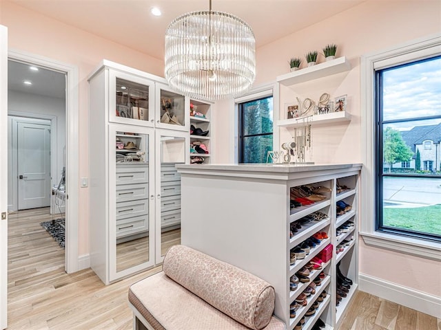 15825 Lacebark Ln, Edmond, OK 73013 - spacious closet with light wood finished floors and a chandelier