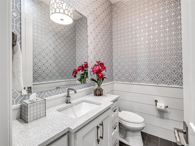 15825 Lacebark Ln, Edmond, OK 73013 - bathroom featuring vanity, toilet, wallpapered walls, and wainscoting