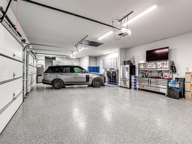 15825 Lacebark Ln, Edmond, OK 73013 - garage with washing machine and clothes dryer, a garage door opener, and freestanding refrigerator