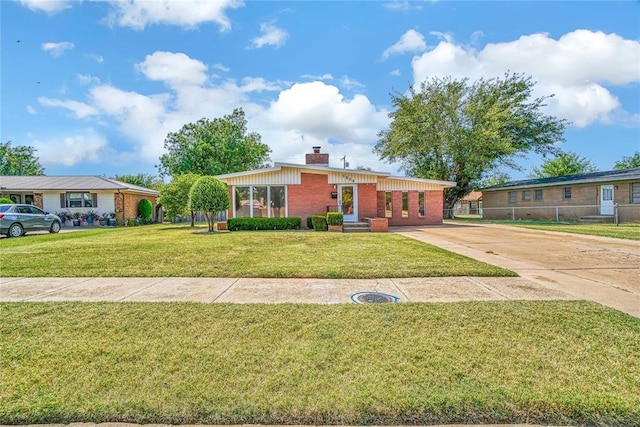 1909 N Flamingo Ln, Altus, OK 73521 - view of front of home featuring a chimney, driveway, a carport, and brick siding