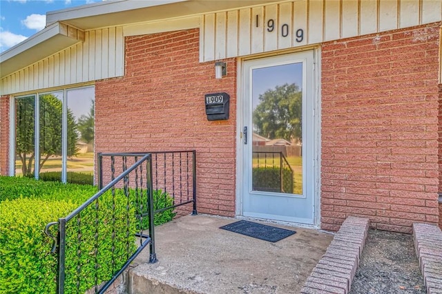 1909 N Flamingo Ln, Altus, OK 73521 - view of exterior entry with board and batten siding and brick siding