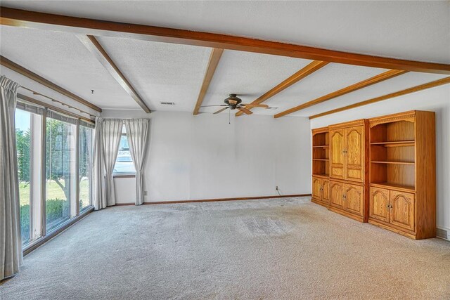 1909 N Flamingo Ln, Altus, OK 73521 - unfurnished living room with light carpet, beam ceiling, ceiling fan, and baseboards