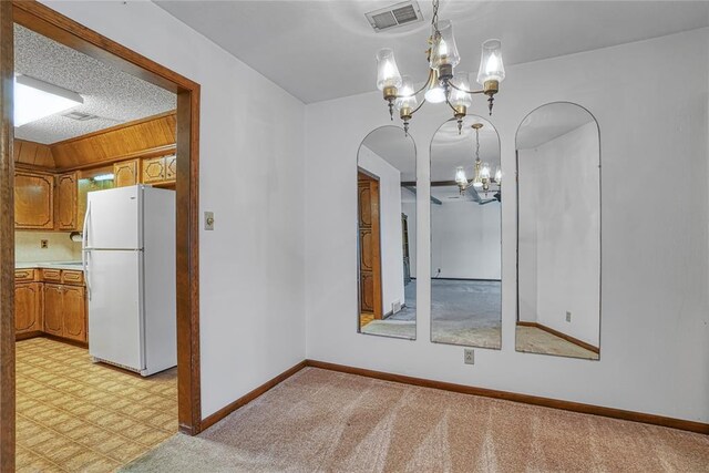 1909 N Flamingo Ln, Altus, OK 73521 - unfurnished dining area featuring a chandelier, arched walkways, baseboards, light colored carpet, and light floors