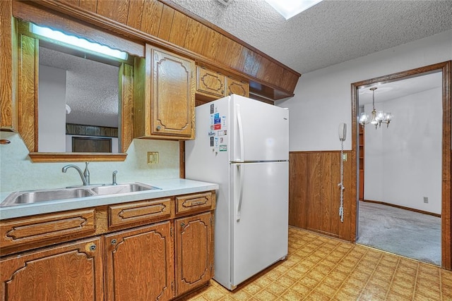 1909 N Flamingo Ln, Altus, OK 73521 - kitchen featuring freestanding refrigerator, a sink, a textured ceiling, brown cabinets, and light floors