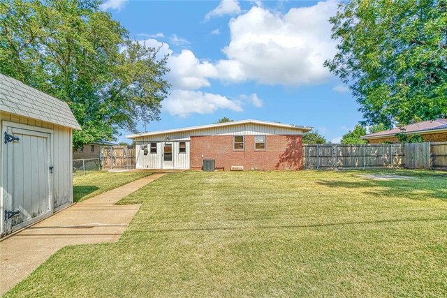 1909 N Flamingo Ln, Altus, OK 73521 - back of property featuring cooling unit, brick siding, and an outbuilding