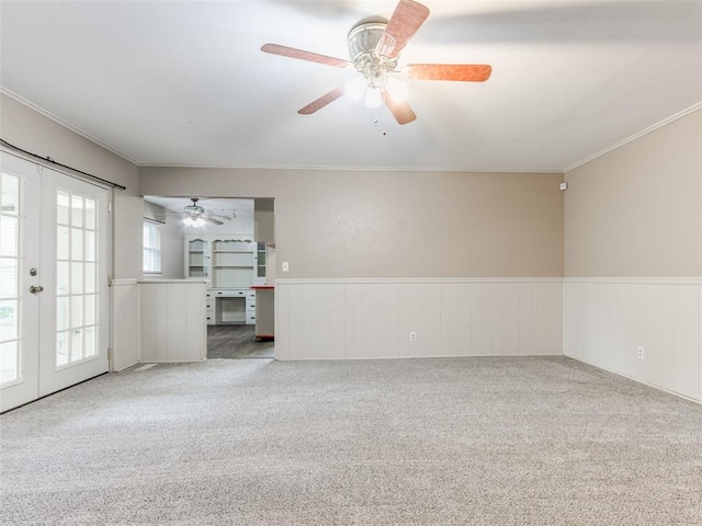 1505 W Blake St, El Reno, OK 73036 - empty room featuring carpet floors, a wainscoted wall, a ceiling fan, ornamental molding, and french doors