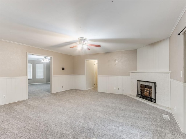 1505 W Blake St, El Reno, OK 73036 - unfurnished living room with ceiling fan, wainscoting, a brick fireplace, carpet floors, and ornamental molding