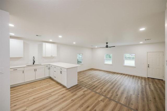 2817 N Donnelly Ave, Oklahoma City, OK 73107 - kitchen with a sink, light wood-type flooring, a peninsula, light countertops, and recessed lighting