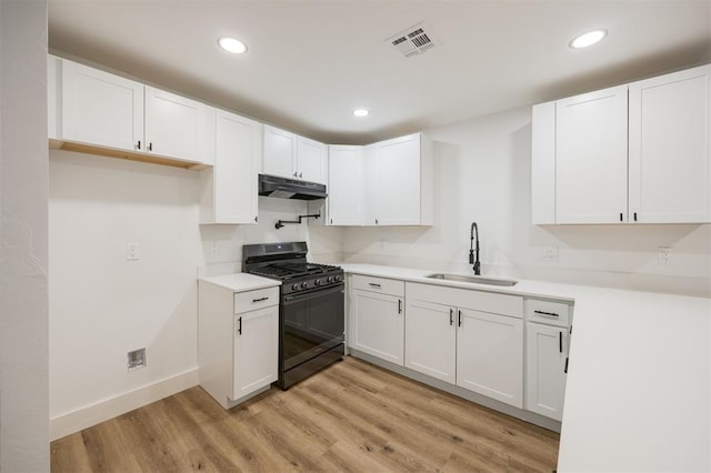 2817 N Donnelly Ave, Oklahoma City, OK 73107 - kitchen featuring gas stove, a sink, under cabinet range hood, white cabinetry, and recessed lighting