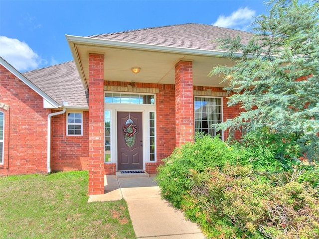 12275 Autumn Brk, Guthrie, OK 73044 - property entrance featuring roof with shingles, brick siding, and a lawn