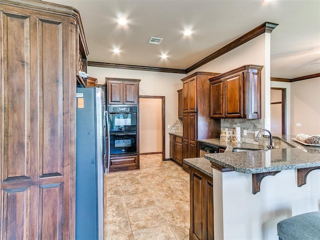 12275 Autumn Brk, Guthrie, OK 73044 - kitchen featuring freestanding refrigerator, a sink, a peninsula, a kitchen breakfast bar, and dark stone counters