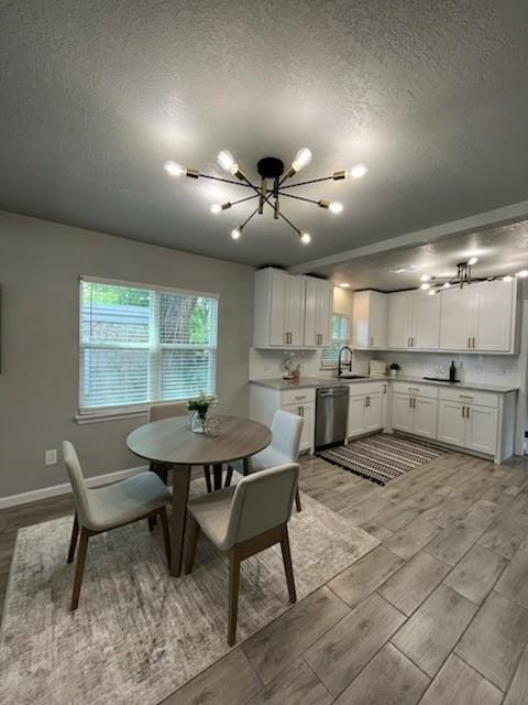 701 Iowa St, Norman, OK 73069 - dining room featuring a chandelier, a textured ceiling, wood finish floors, and baseboards