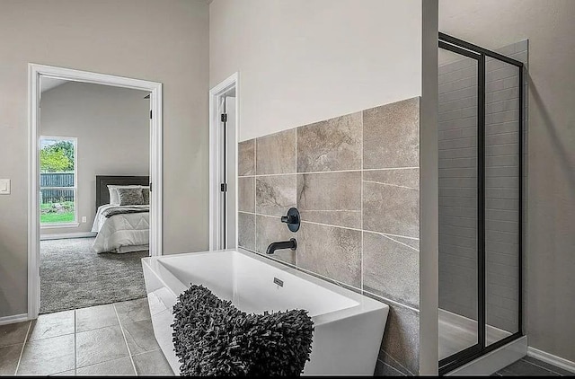 3921 Bandera Trl, Norman, OK 73071 - ensuite bathroom with a freestanding tub, a stall shower, tile walls, and baseboards