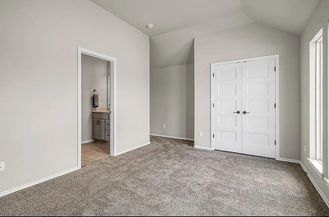 3921 Bandera Trl, Norman, OK 73071 - unfurnished bedroom featuring carpet floors, a closet, lofted ceiling, ensuite bath, and baseboards