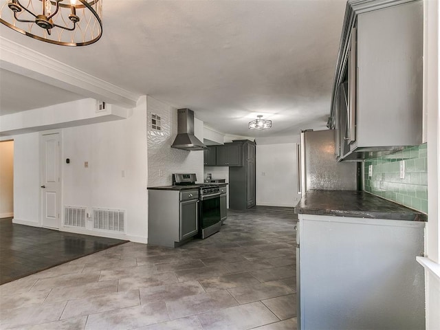 121 NW 27th St, Oklahoma City, OK 73103 - kitchen featuring gas range, wall chimney range hood, dark countertops, a chandelier, and backsplash