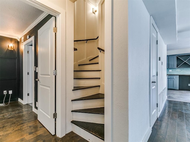121 NW 27th St, Oklahoma City, OK 73103 - hallway with dark wood-type flooring, crown molding, a textured ceiling, and stairway