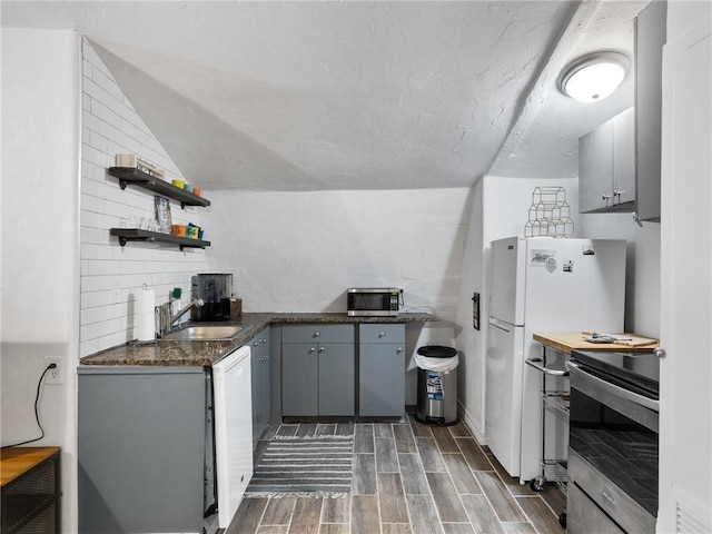 121 NW 27th St, Oklahoma City, OK 73103 - kitchen with stainless steel appliances, a sink, wood tiled floors, open shelves, and gray cabinets