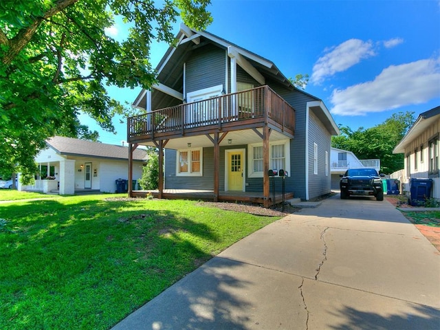121 NW 27th St, Oklahoma City, OK 73103 - view of front facade with a balcony, driveway, a front lawn, and a porch