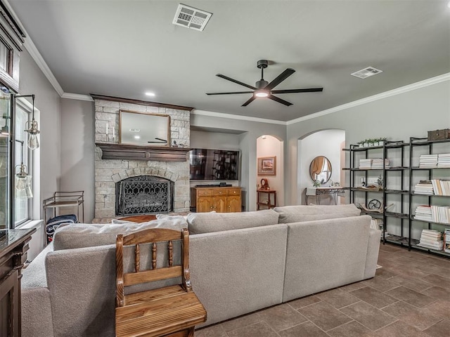13505 Shady Pine Cir, Edmond, OK 73025 - living room featuring a fireplace, arched walkways, a ceiling fan, crown molding, and dark stone finish floors