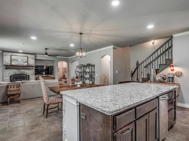 13505 Shady Pine Cir, Edmond, OK 73025 - kitchen with arched walkways, ceiling fan, recessed lighting, ornamental molding, and a fireplace