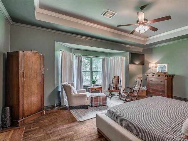 13505 Shady Pine Cir, Edmond, OK 73025 - bedroom with a tray ceiling, wood finished floors, ornamental molding, and baseboards
