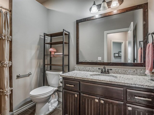 13505 Shady Pine Cir, Edmond, OK 73025 - bathroom featuring toilet, vanity, tile patterned flooring, and baseboards