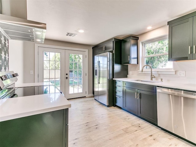 7624 NW 14th Ter, Oklahoma City, OK 73127 - kitchen with appliances with stainless steel finishes, extractor fan, a sink, light countertops, and light wood-style flooring
