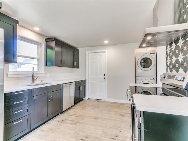 7624 NW 14th Ter, Oklahoma City, OK 73127 - kitchen featuring stacked washer / drying machine, dishwasher, a sink, wall chimney range hood, and light wood-style floors