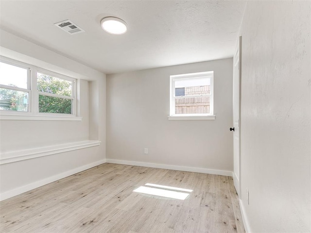 7624 NW 14th Ter, Oklahoma City, OK 73127 - empty room featuring wood finished floors, healthy amount of natural light, and baseboards