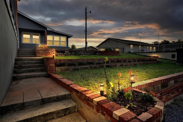 109 Cowan Ave, Fort Cobb, OK 73038 - yard at dusk featuring a lawn and stairs