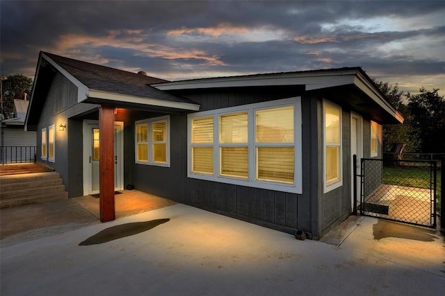 109 Cowan Ave, Fort Cobb, OK 73038 - property exterior at dusk with a patio and a gate