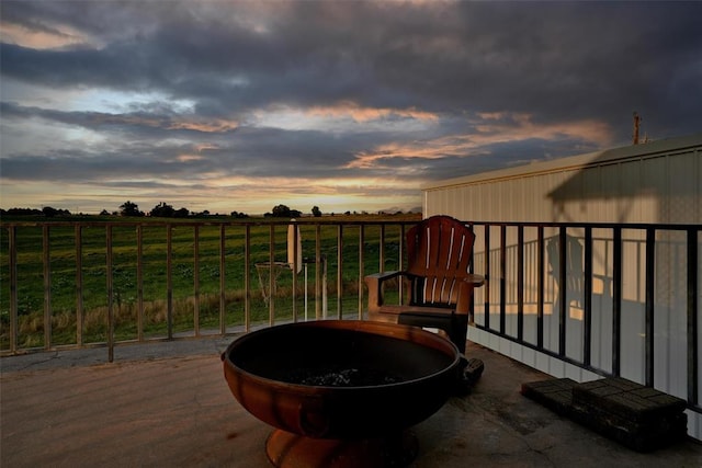 109 Cowan Ave, Fort Cobb, OK 73038 - patio terrace at dusk featuring an outdoor fire pit and a view of countryside
